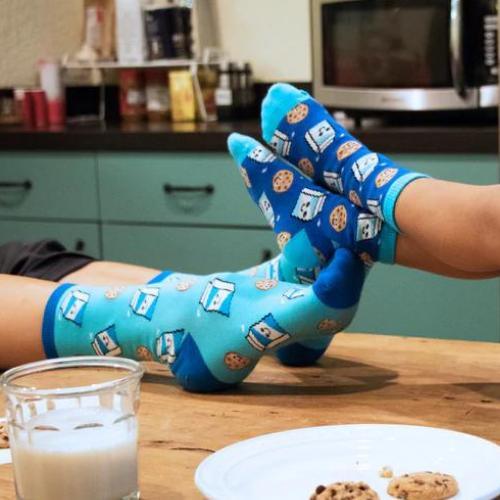 Fun milk and cookie patterned socks in a cozy kitchen setting.