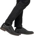 Black brogue dress shoes styled with black jeans.