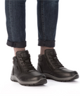 Black high top boots worn with dark blue jeans rolled at the ankle.