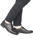 Black derby dress shoes worn with black jeans.
