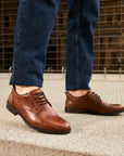 Brown Dress Leather Loafers styled with blue jeans outdoors.