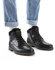 Black ankle boots with black laces worn with light blue jeans and white socks.