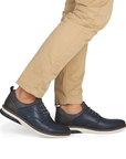 Navy blue shoes worn with beige pants.