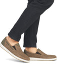 Model wearing taupe Men's Rieker 18266 Loafers paired with black jeans, showcasing casual summer-ready slip-on design.