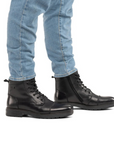 Man wearing blue jeans and black lace up ankle boots.