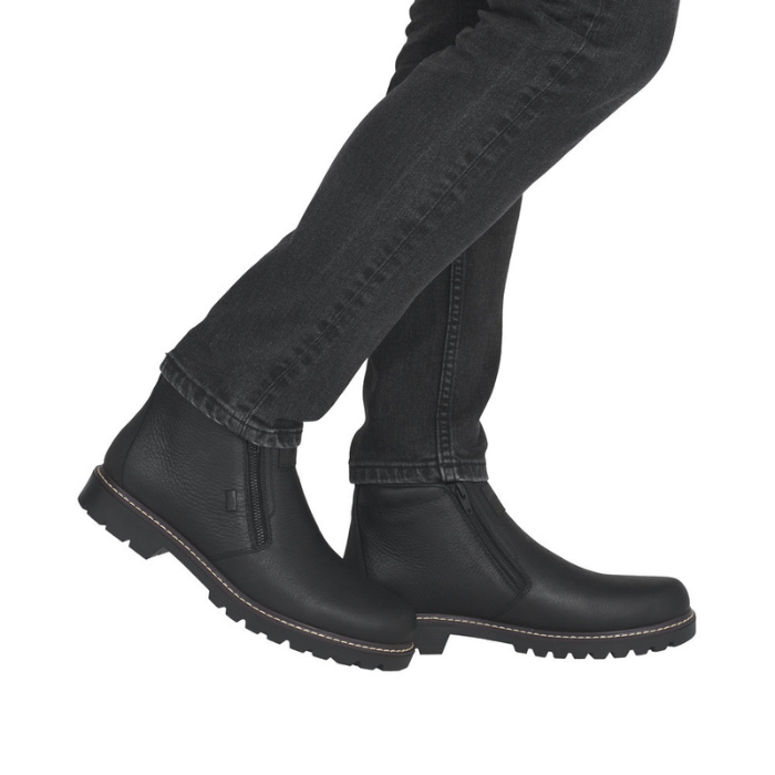 Man wearing black jeans and black dual zipper leather ankle boots.