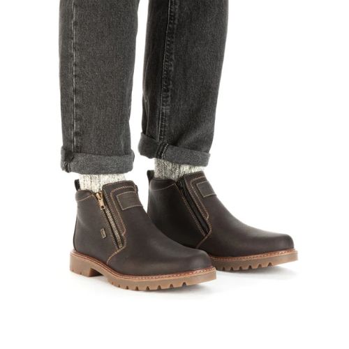 Man wearing black wash jeans and brown side zipper leather ankle boots.