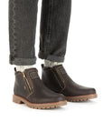 Man wearing black wash jeans and brown side zipper leather ankle boots.