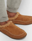Tan suede Slippers worn by a man in grey jogging pants.
