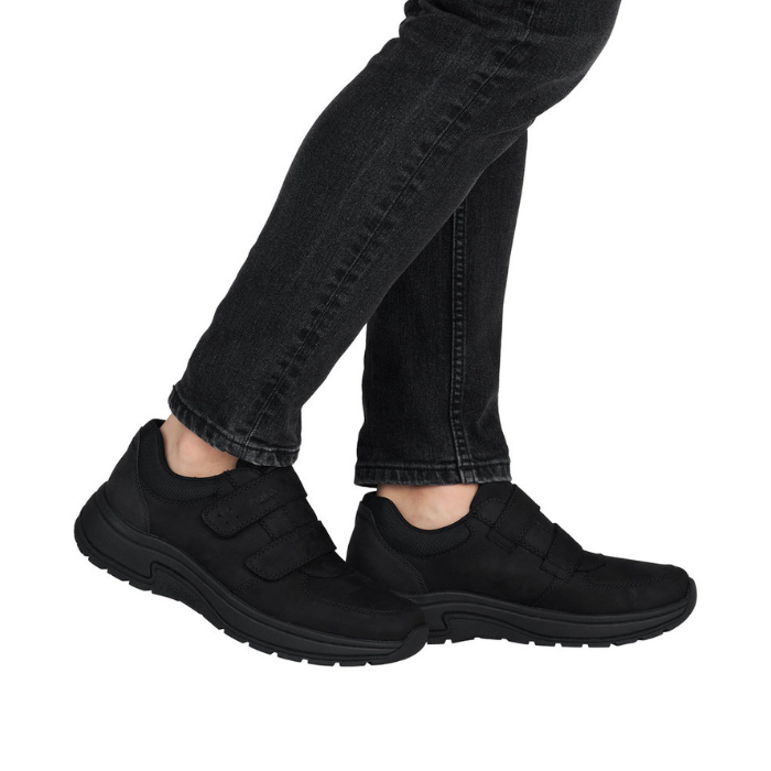 Black slip-on shoes worn with black jeans.