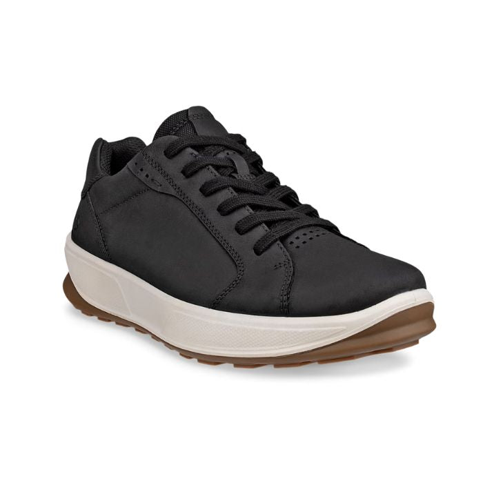 Black leather sneaker with thick white midsole and brown outsole.