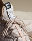 Close-up of Moea Gen6 Pineapple Laced Sneakers showing eco-friendly knit upper, beige cotton laces, and branded tongue label. Ideal for sustainable fashion.