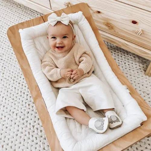 Smiling baby wearing Robeez Ivory Elephant Soft Soles, showcasing stylish and supportive baby shoes with soft suede soles for balance and growth.