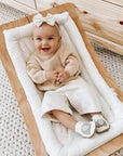 Smiling baby wearing Robeez Ivory Elephant Soft Soles, showcasing stylish and supportive baby shoes with soft suede soles for balance and growth.