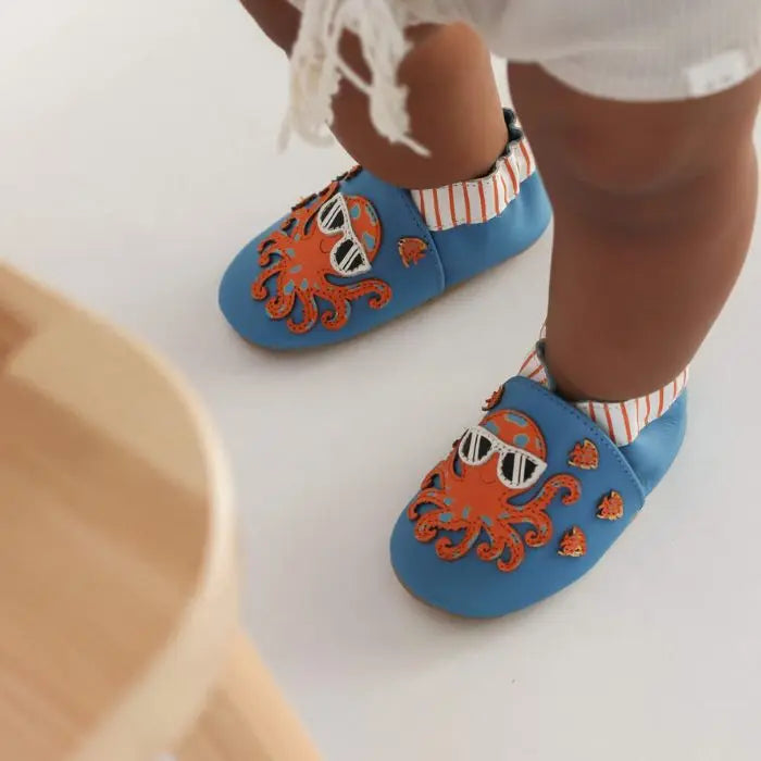 Toddler wearing Robeez Octopus Soft Sole Shoes, featuring flexible leather and slip-resistant soles for safe early walking.