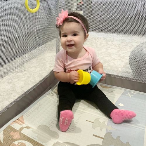 Toddler wearing Robeez pink non-skid socks from the 3 Pack Baby Socks set, designed for comfort and secure fit during playtime.