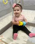 Toddler wearing Robeez pink non-skid socks from the 3 Pack Baby Socks set, designed for comfort and secure fit during playtime.