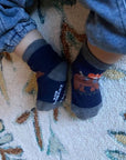 Toddler wearing Robeez animal-themed non-skid socks from the 3 Pack Baby Socks set, ideal for secure steps and playful movement.