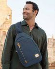 Man carrying Travelon Anti-Theft Sling Bag across chest, highlighting its ergonomic fit, anti-theft features, and modern travel-ready style.