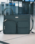 Teal Travelon Anti-Theft Essentials Patch Pocket Crossbody displayed in an airport setting, highlighting its travel-friendly design and security.
