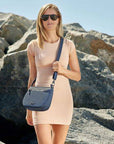 Woman wearing the Travelon Anti-Theft Crossbody Bag in navy, ideal for stylish and secure travel on the go.