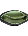 Interior of black Travelon Anti-Theft Roam E/W Crossbody Bag featuring green lining and organized compartments with RFID protection.