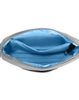Interior of light gray Travelon Anti-Theft Roam E/W Crossbody Bag showing bright blue lining and RFID-protected compartments.