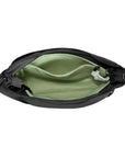 Interior of black Travelon Anti-Theft Roam Medium Crossbody Bag featuring green lining, RFID-blocking pocket, and organized compartments.