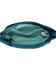 Interior of teal Travelon Anti-Theft Roam Medium Crossbody Bag showing light blue lining, RFID-blocking pocket, and multiple compartments.