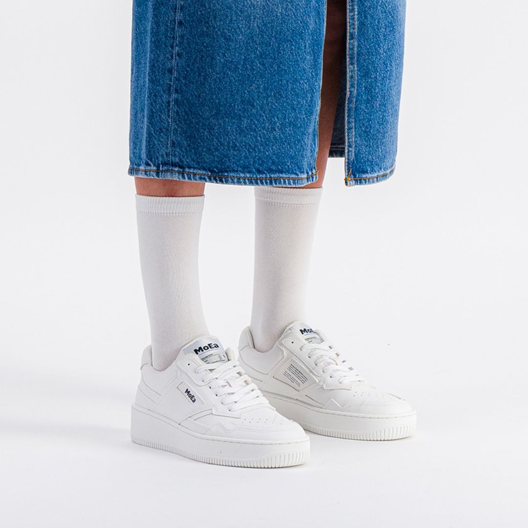 Model wearing Moea Gen1 Grape Vegan Sneakers styled with a denim skirt and socks, perfect for casual eco-conscious women's fashion.