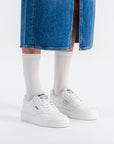 Model wearing Moea Gen1 Grape Vegan Sneakers styled with a denim skirt and socks, perfect for casual eco-conscious women's fashion.