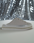 Bernie Mev TW Jive Clog for women displayed against a sparkly backdrop, emphasizing its glittery toe cap and stylish slip-on design.