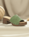 Stylish green suede Bos&Co Marly heeled block sandal displayed on neutral fabric backdrop, ideal for summer fashion.