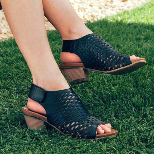 Woman with legs crossed wearing the Lacey sandal in black.