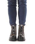 Front view of Women's L'Artiste Carnelian Combat Boots worn with jeans, highlighting lace-up design and bold combat boot silhouette.