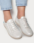 Model wearing white Cloud Aika women's sneakers with soft Italian leather and side zipper, styled with light denim jeans.