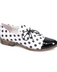 Woman's Oxford shoe in white with black polka dotted leather with black laces, slip on style, black patent toe cap and a low stacked heel.
