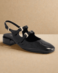 Black Django & Juliette Viraz Slingback Heels displayed on neutral background, highlighting square toe and gold buckle accents.