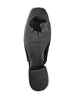 Outsole view of black Django & Juliette Viraz Slingback Heels showing engraved silhouette and quote, with square toe and block heel.