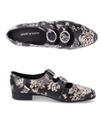 Pair of Black dress shoe with brown floral pattern and two velcro straps with detail buckles.