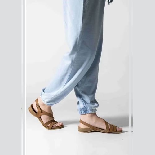 Model wearing Women's Backstrap Leather Sandal in brown, styled casually with light blue pants.