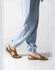 Model wearing Women's Backstrap Leather Sandal in brown, styled casually with light blue pants.