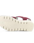 Light treaded lugged outsole of wedge sandal with Fly London on heel and a Fly bug on ball of foot.