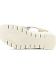 Light treaded lugged outsole of wedge sandal with Fly London on heel and a Fly bug on ball of foot.