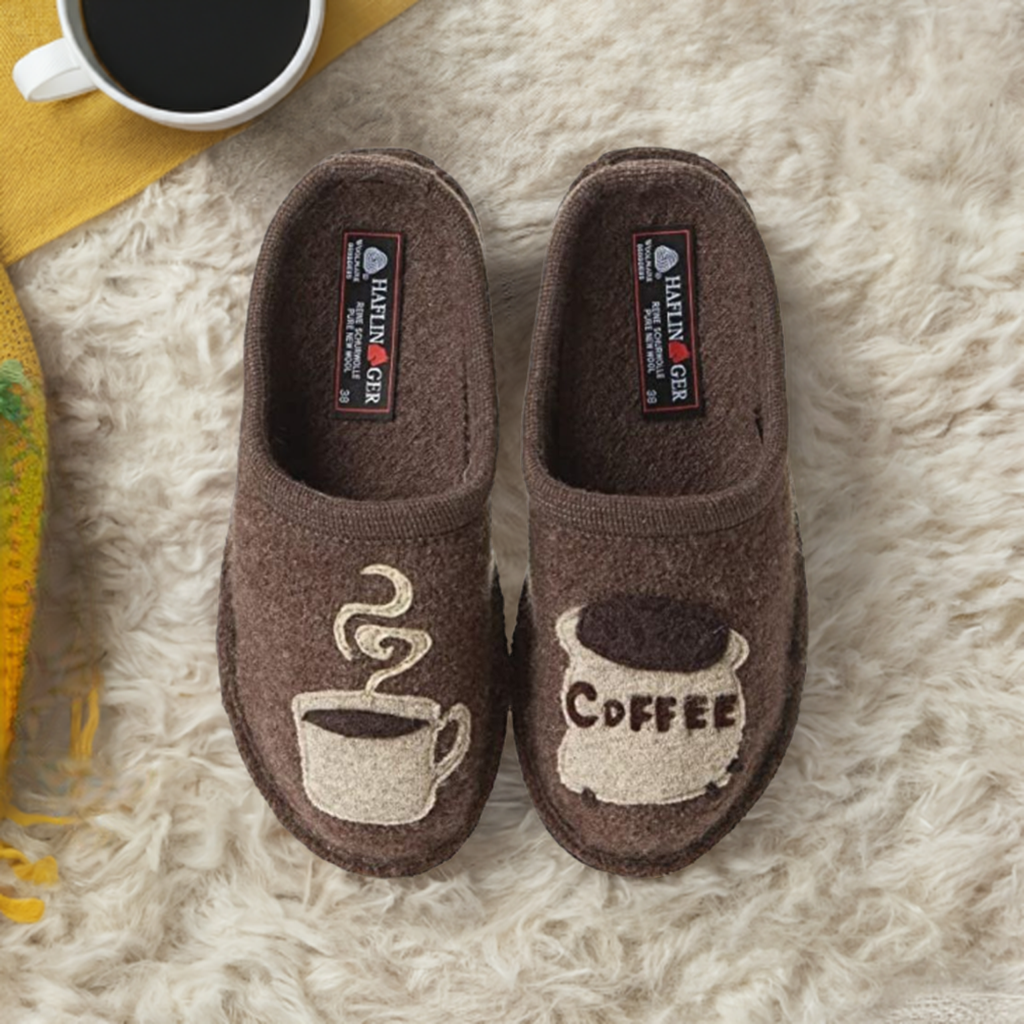 Women's Haflinger Coffee wool slippers on plush rug, featuring cute coffee-themed embroidery, ideal for cozy mornings at home.