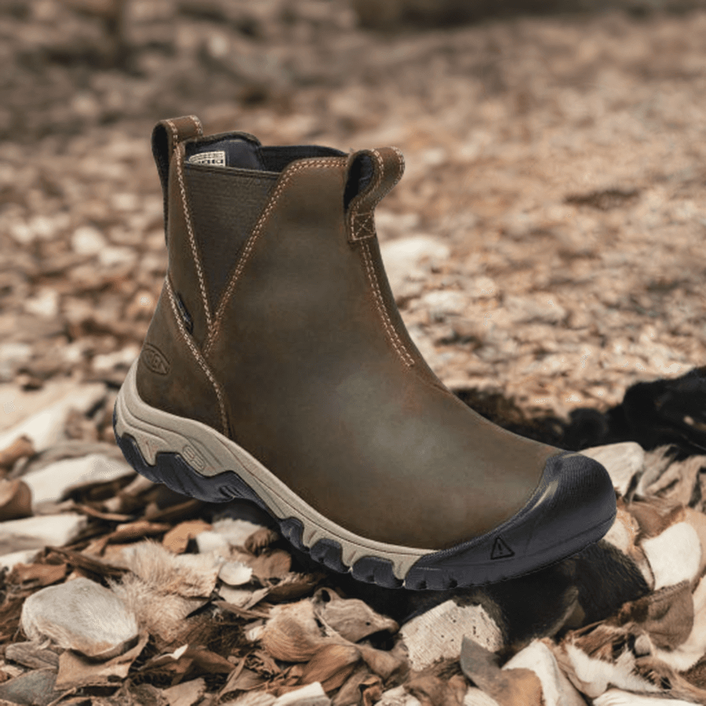 Women's Keen Greta Chelsea Boot styled outdoors on rocky terrain, showcasing its waterproof build and rugged winter-ready design.