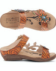 Top and side views of the orange Women's L'Artiste Aymee Sandal showcasing floral cutouts and hand-painted leather craftsmanship.
