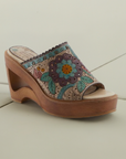 Women's L'Artiste Calle heeled slide sandal with artistic floral leather upper and cutout wooden wedge heel, perfect for stylish casual wear.