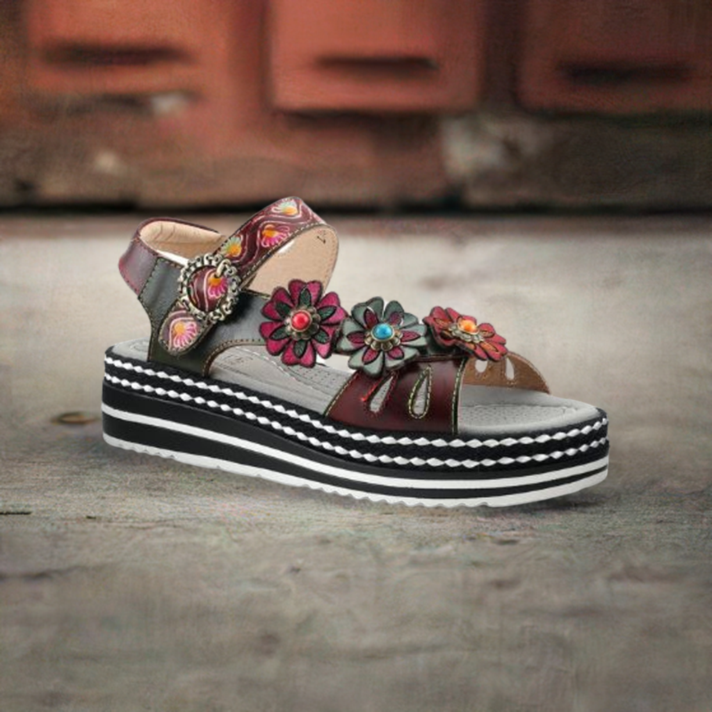 Women's L'Artiste Laga backstrap sandal displayed on rustic background, highlighting colorful floral leather and platform sole.