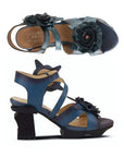 Pair of Heeled sandals in hand-painted deep blue leather with 3D flower accents, tan L'Artiste logo'd footbed and a sculpted black wedge heel.